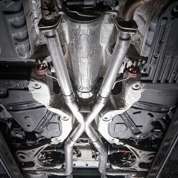 Underneath view of a car's X-pipe exhaust system.