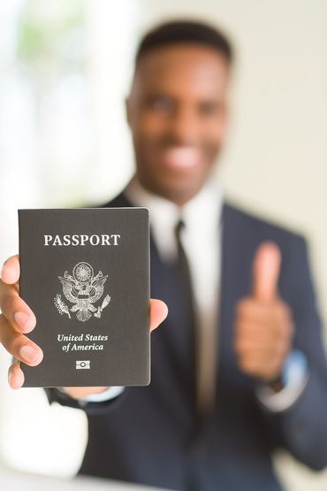Man holding a U.S. passport and giving a thumbs up.