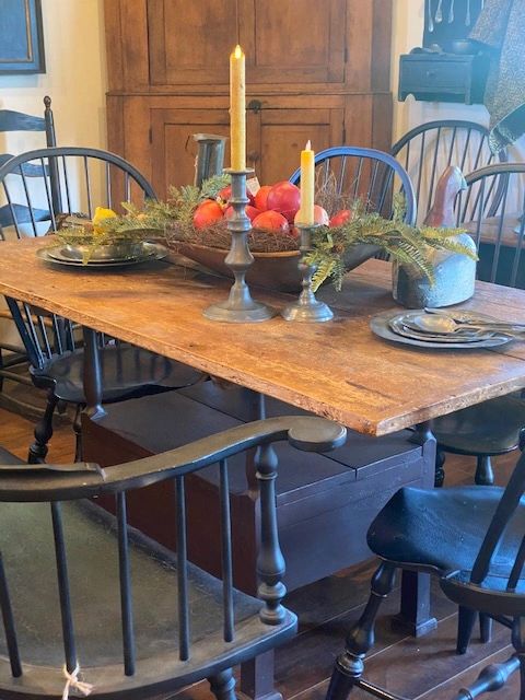A Wm Wallick chair table with bow back Windsor chairs with a trencher filled with apples & pewter.