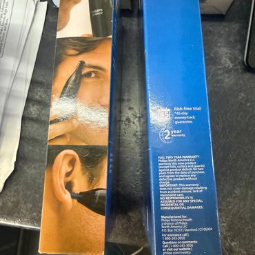Philips Norelco personal grooming device with usage instructions and warranty details.
