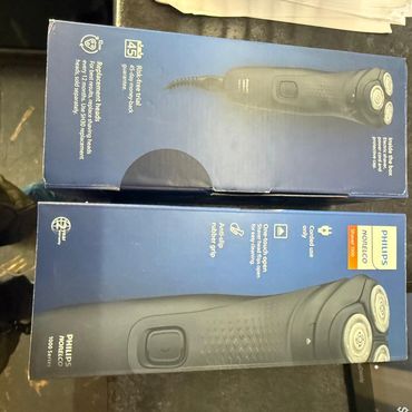 Box of Philips Norelco electric shaver with three rotary heads and anti-slip rubber grip.