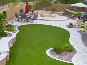 Modern backyard with artificial grass and seating area.