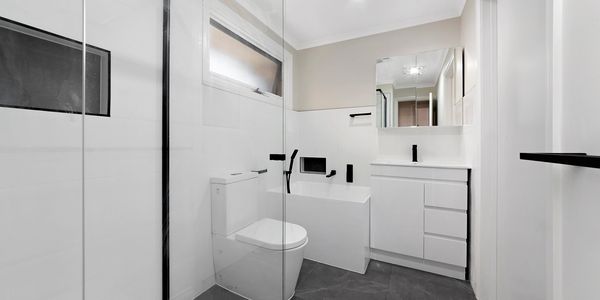 Minimalist white bathroom with black accents.
