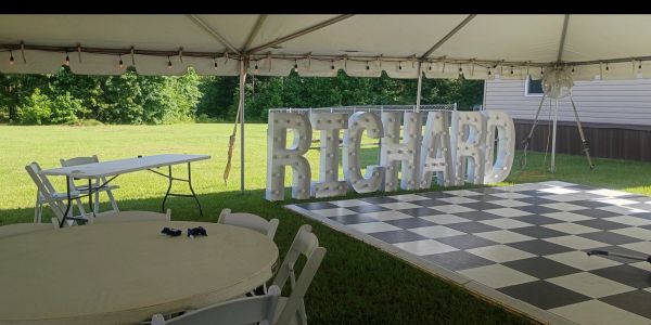 Event setup with chairs, tables, and RICHARD sign.