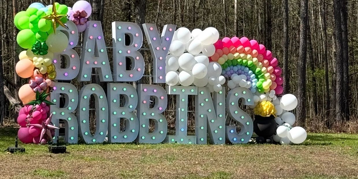 Colorful balloon decoration with letters spelling 'BABY ROBBINS'.