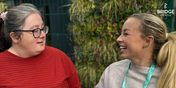 Two women engaged in a friendly conversation outdoors.