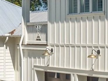 Modern white house with a large driveway and basketball hoop.