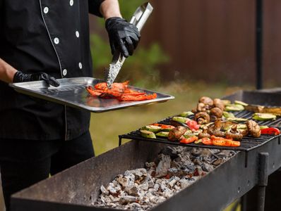 chef grilling meat and vegetables outdoors