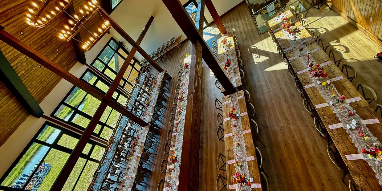 Modern rustic barn wedding reception at a private Catskills wedding venue with farm tables.