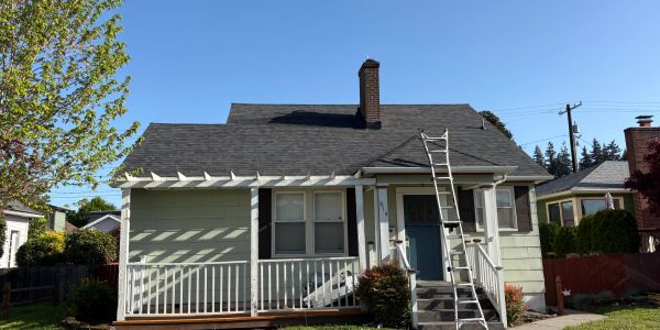 Small house with a ladder leaning on the roof.