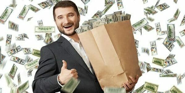 Man happily holding bag full of money with cash falling around.
