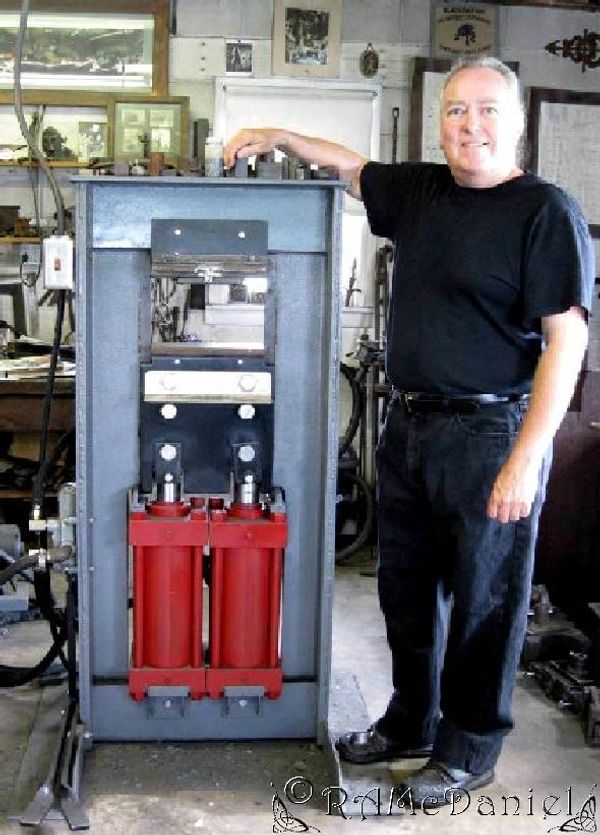 Blacksmith Randy McDaniel posing with his 60-ton hydraulic forging press at Expressive Metals School