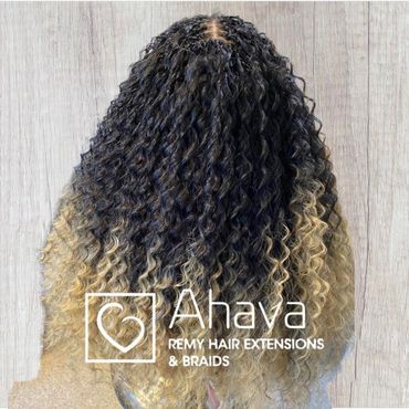 Curly hair extensions with a dark to blonde ombre effect.