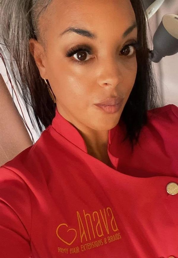 Woman wearing a red Ahava Remy Hair Extensions & Braids jacket.