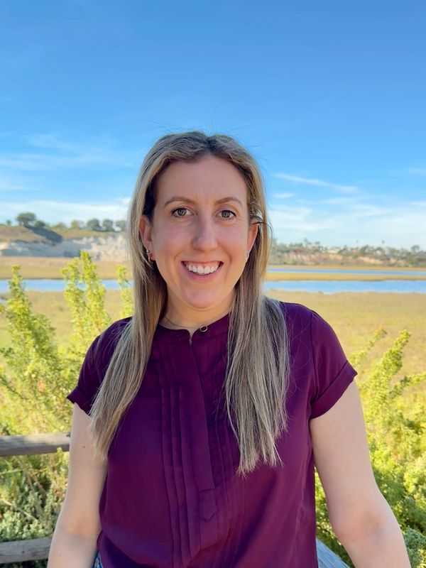 Photo of Dr. Rahman. Woman with long blonde hair wearing purple shirt.