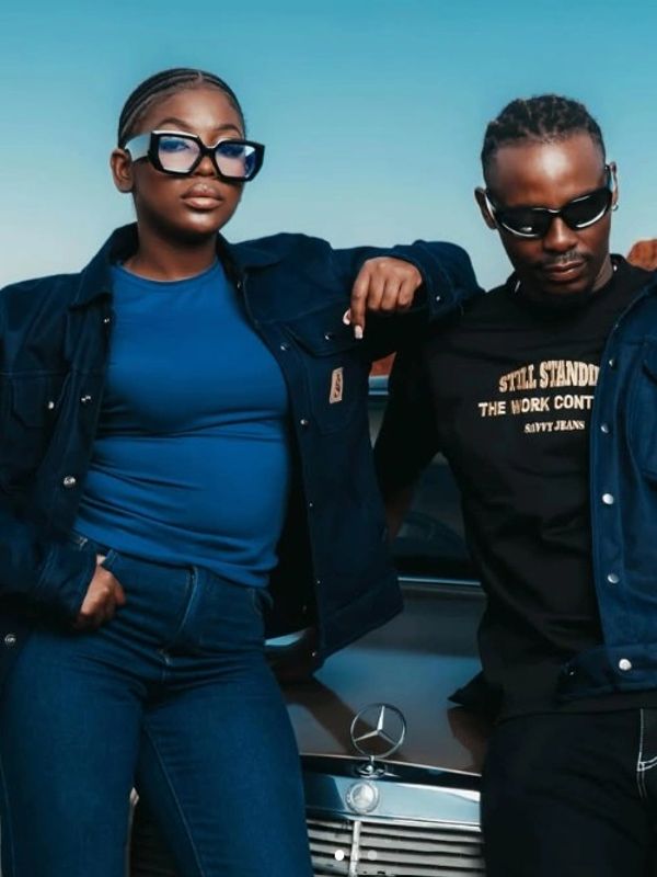 Two stylish people leaning against a Mercedes car.