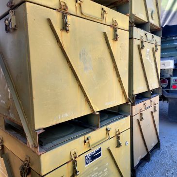 Stacked military-style storage containers outdoors.