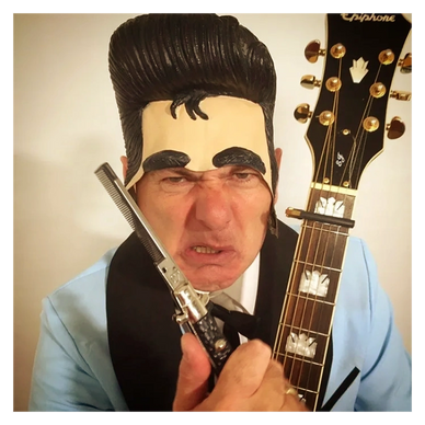 Person in an Elvis-style wig holding a guitar and a switchblade comb.