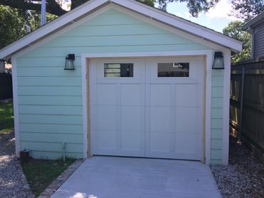 White single garage door on a pale-blue garage in Metairie, Louisiana