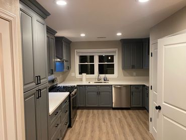 Kitchen with gray cabinets, white countertops, and recessed ceiling lights