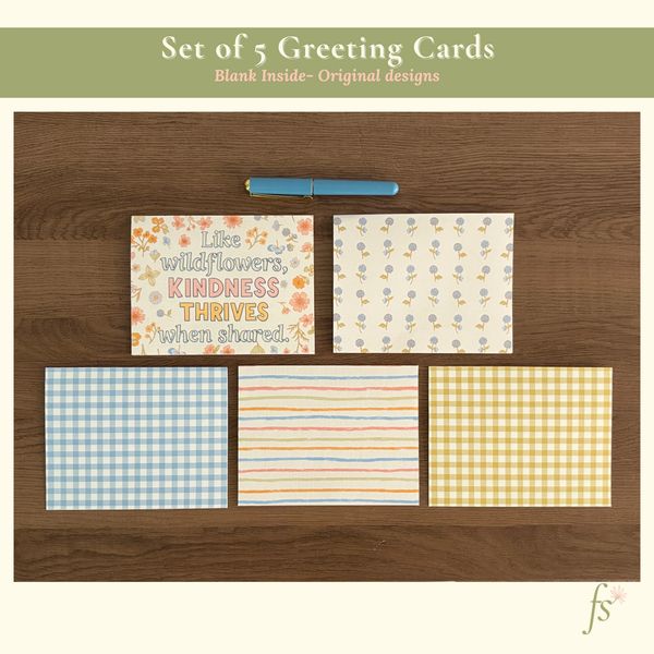 Set of five wildflower-themed greeting cards with hand-illustrated designs on wood background