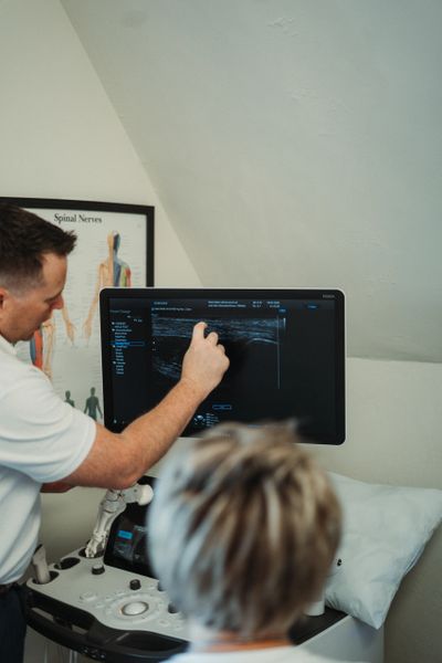 A medical professional explaining ultrasound results to a patient.