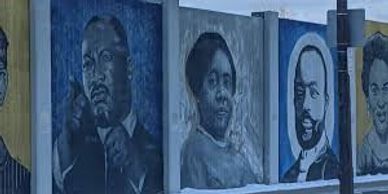 Mural featuring portraits of influential African American leaders on a city wall.