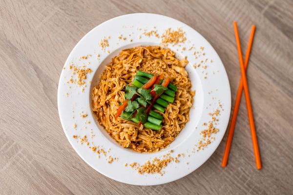 A veg dish in a plate with a pair of chopsticks