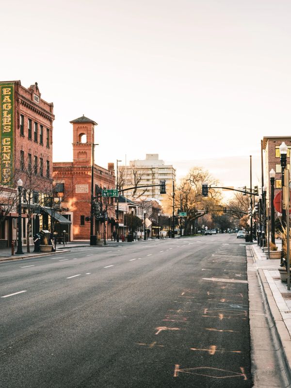Empty city street at sunset with historical buildings.