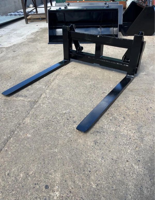 Black metal forklift attachment on a concrete floor.