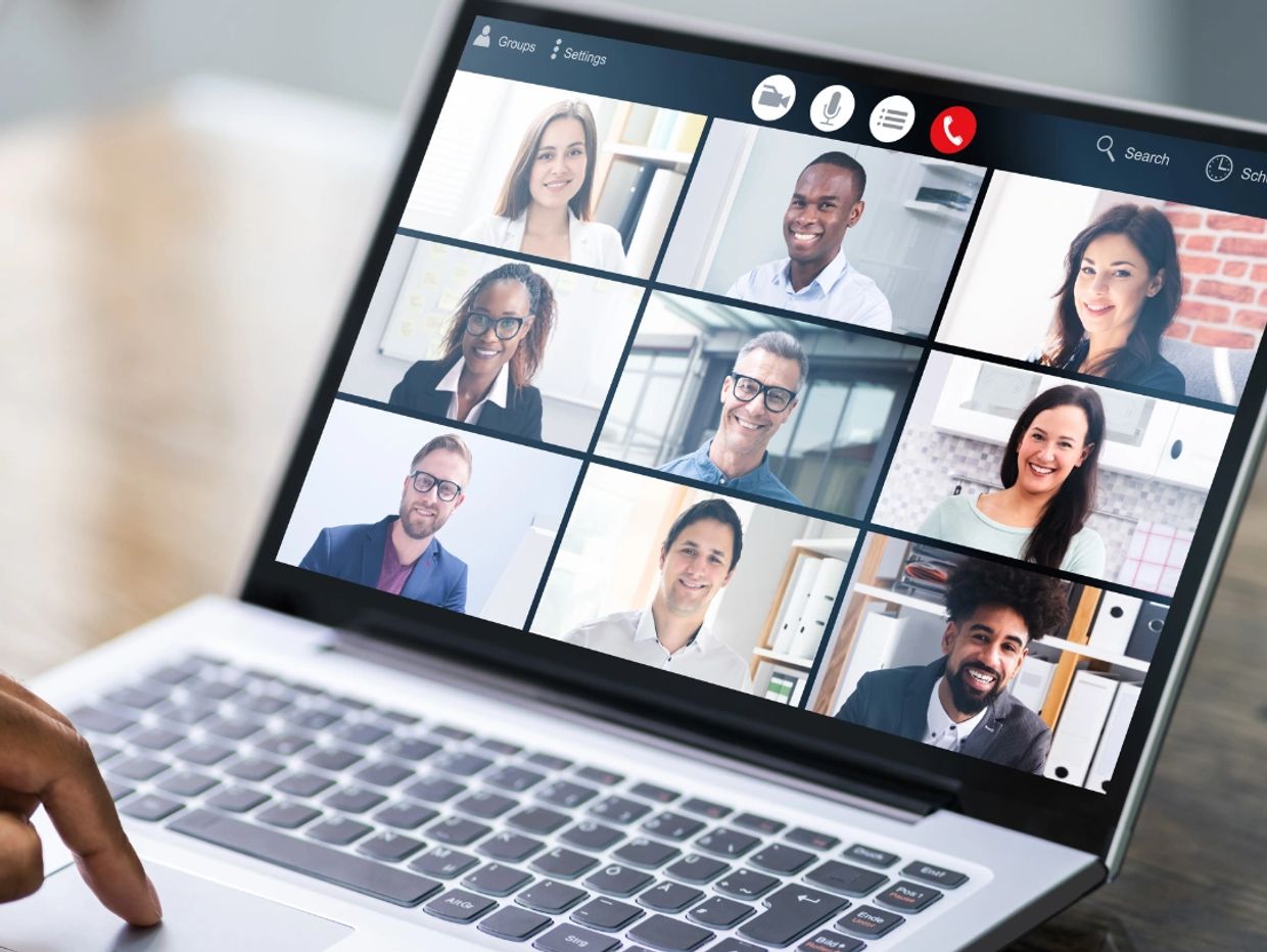 Laptop showing a group video call with nine participants.