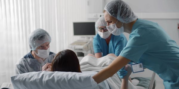 Doctors assisting a woman giving birth