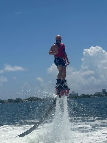 A man enjoying flyboarding above the water
