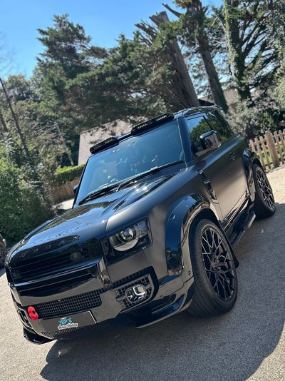Sleek black SUV parked outdoors on a sunny day.