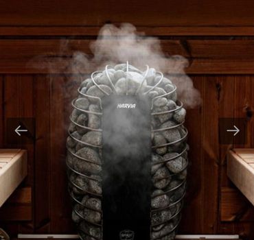 A Harvia sauna heater with hot stones emitting steam in a wooden sauna room.