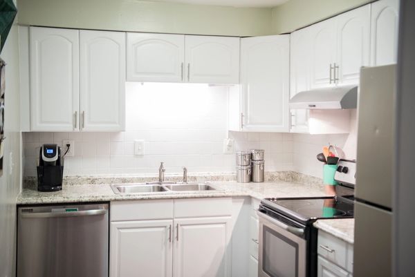 Kitchen After - painted oak cabinets, new counter, flooring, wall and ceiling paint & overhead light