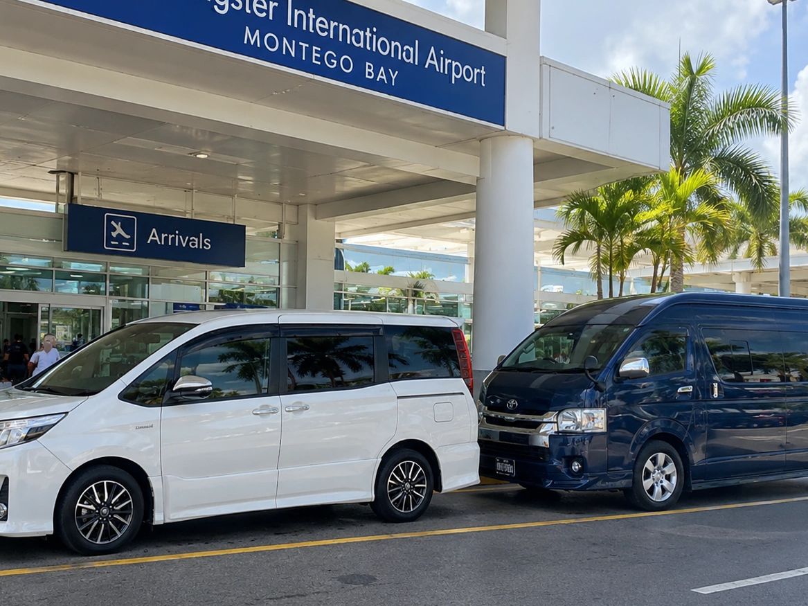 Arrival area at Montego Bay airport with parked vans.