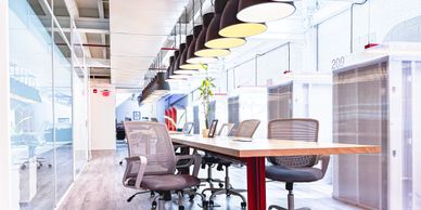 Modern office space with ergonomic chairs and a long wooden table.