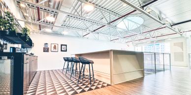 Modern kitchen with bar stools and geometric floor tiles.