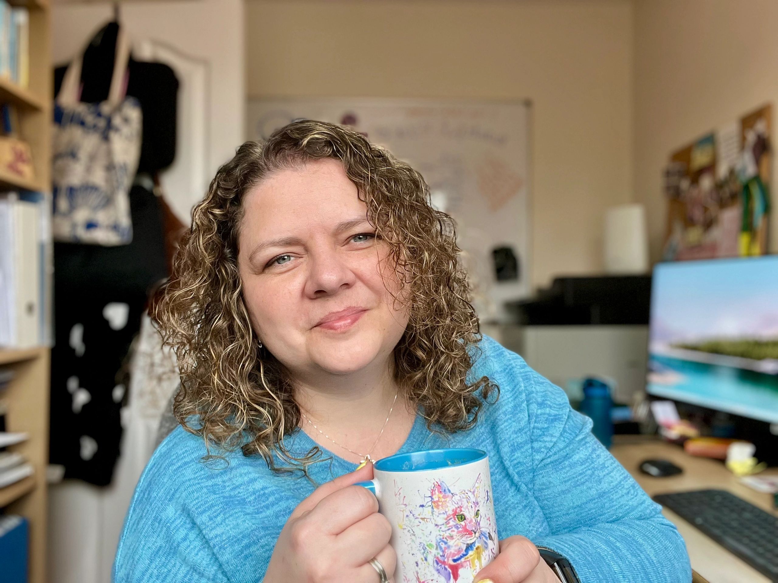Life Coach Ella with tea in cat mug smiling