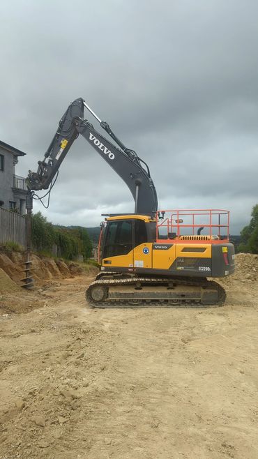 A twenty tonne Volvo excavator drilling holes for a retaining wall.
