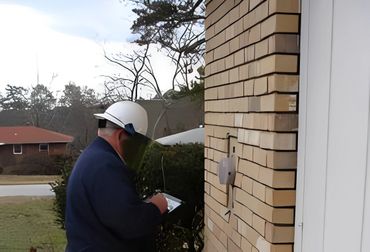 Worker checking digital utility meter.