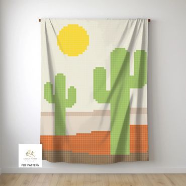 chair throw with two saguaros and a sun against a muted desert background