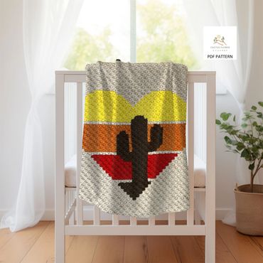 baby blanket with a 3 color retro heart and a large saguaro cactus, haning on a crib