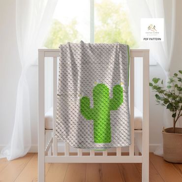 Baby blanket with a small green saguaro with white and yellow flowers, hanging over the edge of a cr