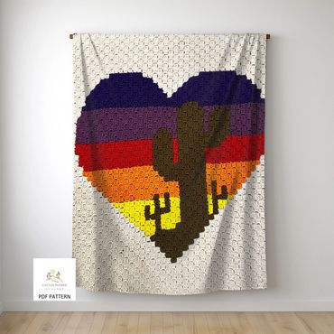 sofa throw with three saguaro cacti sitting inside a large five color sunset striped heart