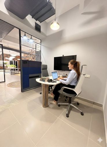 Woman working on a laptop in a modern office meeting room.
