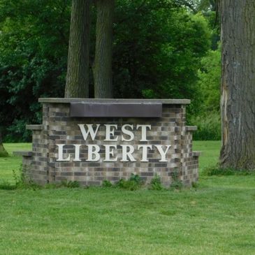 Brick sign for West Liberty in a grassy area.