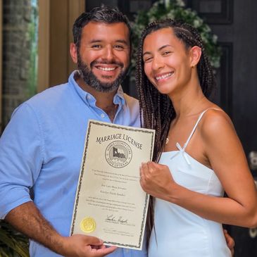 Happy couple holding their marriage license.