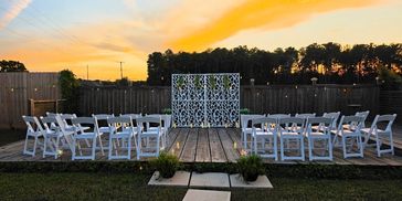 Outdoor wedding ceremony setup at sunset.
